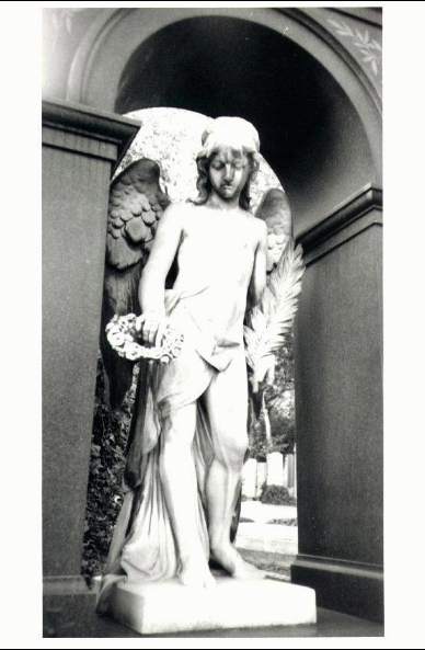 black and white photograph of a statue of a young angel holding a wreath - Vienna